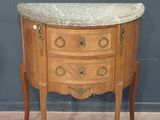 une petite commode à plateau en marbre posée sur un socle