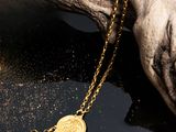 un gros plan d'un collier en or posé sur un morceau de bois