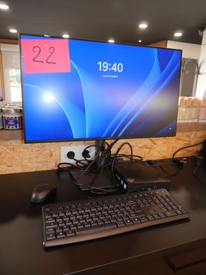 a computer monitor sitting on a desk with a keyboard and mouse
