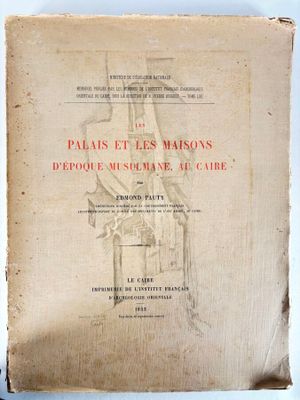 un vieux livre posé sur une table, à côté d'une paire de ciseaux