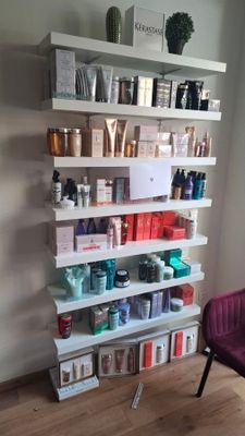 a shelf that has many different types of hair products on it