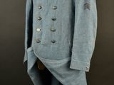 an old blue coat with buttons on a mannequin stand