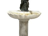 statue d'un garçon assis au sommet d'une fontaine sur laquelle se trouve un oiseau