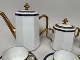 a white and blue tea set with gold trim