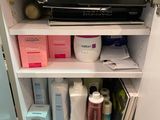 une photo d'une armoire de salle de bains remplie d'objets