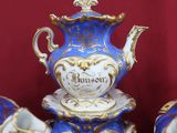 trois théières en porcelaine bleue et blanche posées sur une table rouge