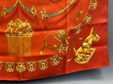 a red and gold scarf with a picture of a man on a horse