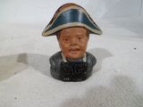 une figurine représentant un homme coiffé d'un chapeau, posée sur une table