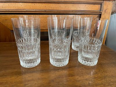 quatre verres sont alignés sur une table devant une commode