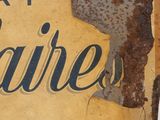 rusted sign on the side of a building with a rusted sign on it