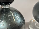 pair of black glass perfume bottles on clear glass bases