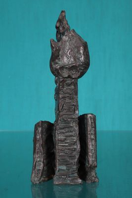 statue d'un homme assis au sommet d'une pile de livres