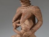un gros plan sur la statue d'une personne tenant un bébé dans ses bras