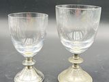 two wine glasses sitting on a table next to each other