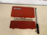 two tools sitting on the floor next to each other