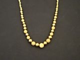 un collier de perles dorées sur fond noir