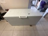 a small white chest freezer sitting on a tiled floor