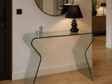 une table en verre sur laquelle se trouvent une lampe et un miroir