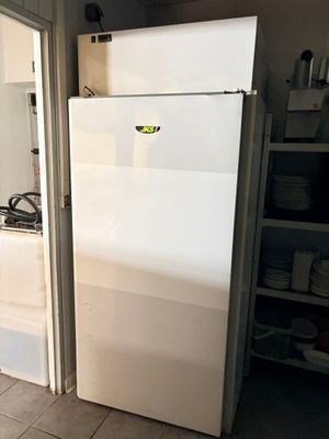 un réfrigérateur blanc dans une cuisine, près d'une fenêtre