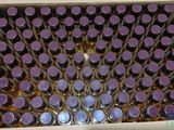 une boîte remplie de bouteilles avec des bouchons violets