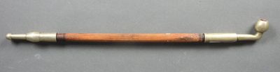 une vieille pipe avec un tuyau en bois, posée sur une table
