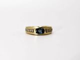 a close up of a gold ring with a blue stone in it