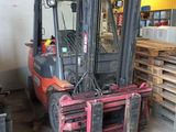 a forklift in a warehouse with pallets of wood