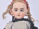 a doll that is wearing a dress and a red headband