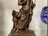 une statue représentant un homme avec un chien, exposée dans une vitrine