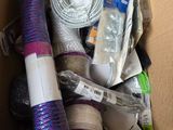 une boîte en carton contenant divers objets, notamment un rouleau de fil et un rouleau de ruban adhésif
