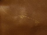 brown leather purse with a metal clasp on a black background