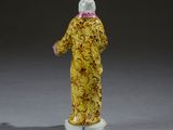a figurine of a woman in a yellow dress
