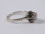 a close up of a diamond ring on a white surface
