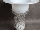un vase en verre surmonté d'un bol blanc