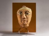 une photo d'une sculpture représentant le visage d'un homme, posée sur un socle