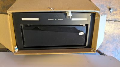 une boîte contenant un micro-ondes, posée sur une table