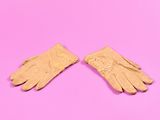 une paire de gants en cuir beige sur fond rose