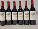 six bouteilles de vin sont alignées sur une table