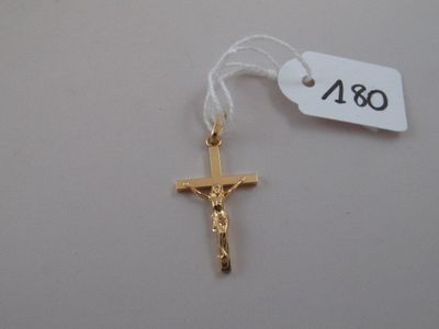 a gold cross on a white string with a price tag