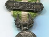 Une vieille médaille est posée sur une table, entourée d'un ruban.