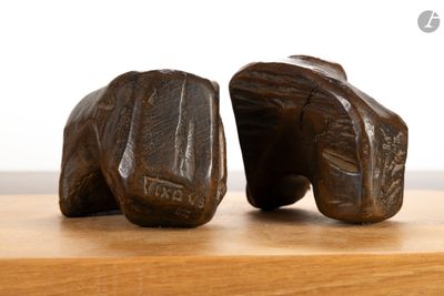 deux sculptures en bois représentant une paire de chaussures posées sur une table