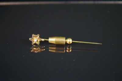 un gros plan sur une paire de boucles d'oreilles en or posées sur une surface noire