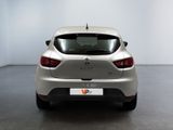 the rear end of a silver car in a room with a white wall