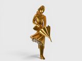 gold statue of a woman holding an umbrella on a white surface