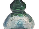 un vase en verre avec un socle vert sur fond blanc