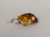 une petite tortue en verre posée sur une table