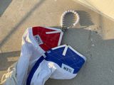 un sac blanc auquel est attaché un sac rouge, blanc et bleu