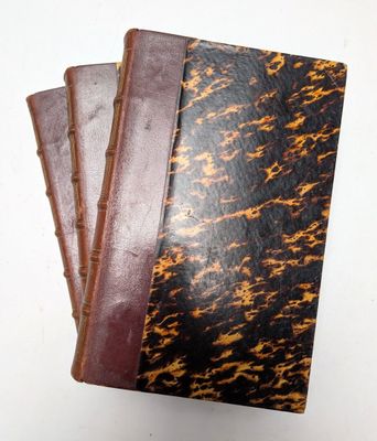 trois carnets en cuir marron et noir empilés les uns sur les autres