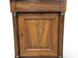 une vieille armoire en bois avec une porte et un tiroir au-dessus
