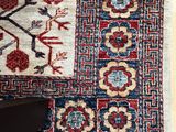 an image of a rug on a wooden floor with a person ' s feet